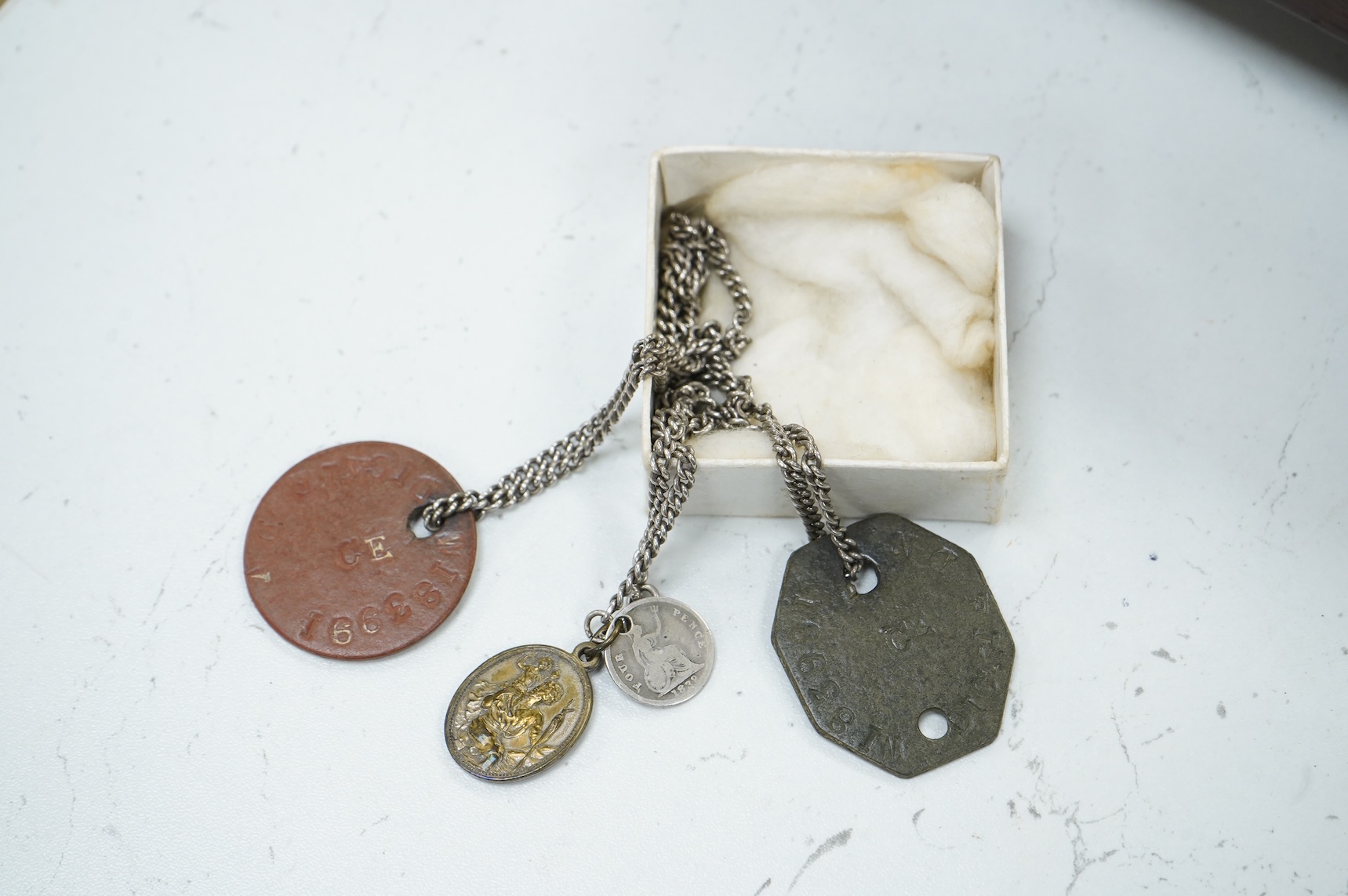 A suitcase of military related items, including; a Manchester Guardian issued early 20th century map of Europe printed on cotton, a First World War trench art match holder the base formed from a cartridge case, two swagg